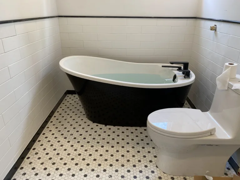 White and black bathroom remodelled with a modern tub and subway tiles.